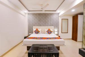 Un dormitorio con una cama grande y una mesa. en FabHotel Arsh Executive Inn, en Bombay
