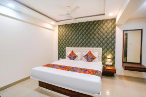 Un dormitorio con una cama blanca y un espejo. en FabHotel Arsh Executive Inn, en Bombay