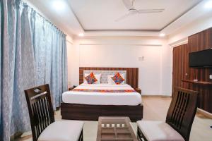 a bedroom with a bed and two chairs and a television at FabHotel Arsh Executive Inn in Mumbai +44 photos