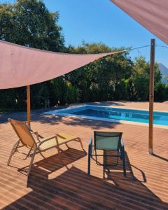 twee stoelen en een parasol naast een zwembad bij Quinta Nova da Machoca in Évora