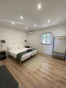 een slaapkamer met een bed en een schilderij aan de muur bij Quinta Nova da Machoca in Évora