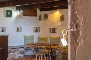 a table and chairs in a room with a wall with pictures at Moinho da Senta in Rio Maior