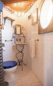 a bathroom with a blue toilet and a window at Moinho da Senta in Rio Maior