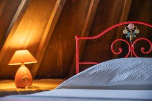 a bed with a red head board and a lamp at Moinho da Senta in Rio Maior