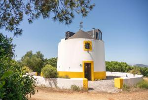 a white and yellow building with a door at Moinho da Senta in Rio Maior +9 photos