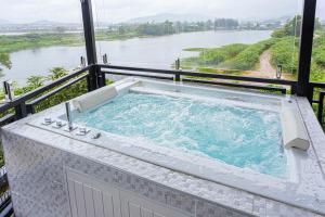 a hot tub on a balcony with a view of a river at Kathu V pool villa 170 in Kathu
