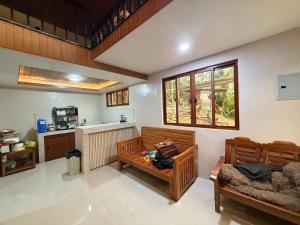 een woonkamer met 2 banken en een keuken bij R&C Transient House in El Nido