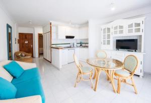 Una cocina y una sala de estar con mesa y sillas. en Playa Delphin 304, en Puerto Naos