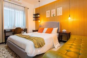 Un dormitorio con una cama y una pared amarilla. en Kathu V pool villa 170, en Ban Kathu (1) 62 fotos más