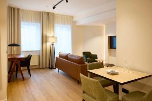 a living room with a couch and a table at Georges Henri Aparthotel in Brussels