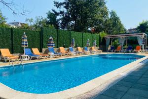 ein Swimmingpool mit Liegestühlen und Sonnenschirmen in der Unterkunft Hotel Sea Star Приморско in Primorsko