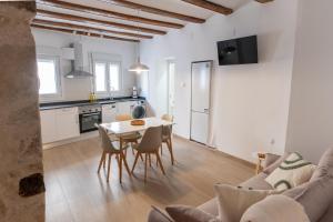 a kitchen and a living room with a table and chairs at Plaza Matarraña in Fuentespalda