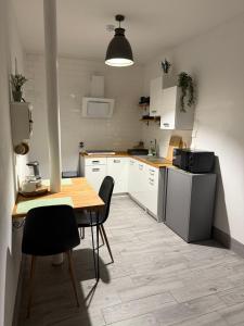 a kitchen with white cabinets and a table and chairs at Pokoje noclegowe in Żyrardów