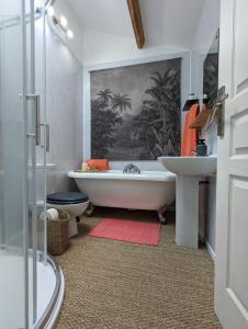 a bathroom with a tub and a toilet and a sink at Grange des Bardins in Villebois-Lavalette