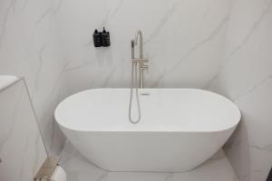a white bath tub in a white bathroom at Asad in Astana +16 photos