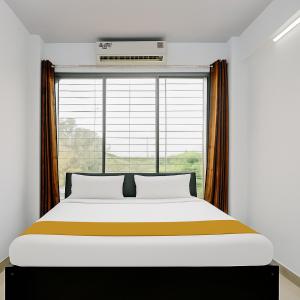 een bed in een kamer met een groot raam bij A R Residency in Navi Mumbai