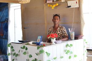 帕特南Mountain Palm patnem beach的一个男人坐在摆放着鲜花的桌子后面的桌子旁。