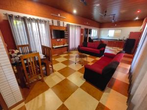 un soggiorno con un divano, un tavolo e una cucina di Private Nature Bungalow with Large Outdoor Area a Kankanādi