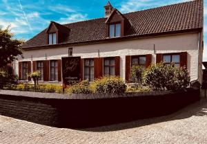 WestvleterenにあるHotel Het Heilig Genotの前に看板がある白い建物