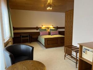 um quarto com uma cama com almofadas cor-de-rosa e uma cadeira em Pension Mountain View Sauerland em Winterberg mais 93 fotografias