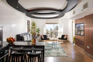 una sala de estar con una mesa y sillas en מילה דירות אירוח - Skyline Eilat, en Eilat