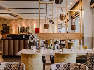 a restaurant with tables and chairs and a counter at Mercure Annecy Sud in Annecy