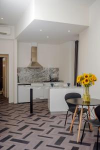 uma cozinha com um vaso de flores sobre uma mesa em Glória Suites Hotel em Lisboa mais 28 fotografias