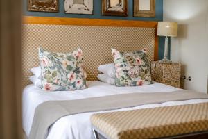 a bed with two pillows on top of it at The Farmhouse Hotel in Langebaan