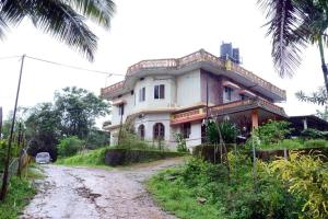 a house on the side of a dirt road at Sri Ranga Homestay in Māvingundi