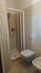 um banheiro com chuveiro, vaso sanitário e pia em residenza il capitano em Roseto degli Abruzzi