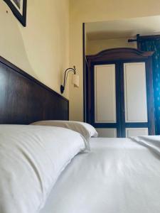 1 dormitorio con 1 cama con sábanas blancas y puerta en Hotel Max, en Aversa