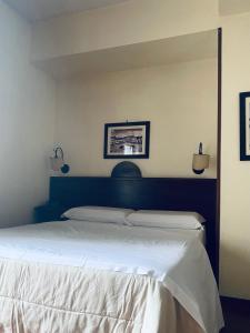Un dormitorio con una cama grande con sábanas blancas. en Hotel Max, en Aversa