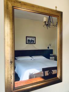 a mirror reflecting a bed in a bedroom at Hotel Max in Aversa