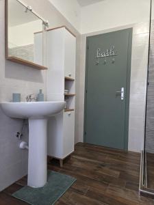 a bathroom with a sink and a door with the word leak at La Casa delle Magnolie in San Canzian dʼlsonzo +17 photos