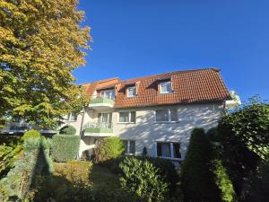 a large white building with a red roof at Apartmenthaus-Usedom Kajüte 10 in Kolpinsee