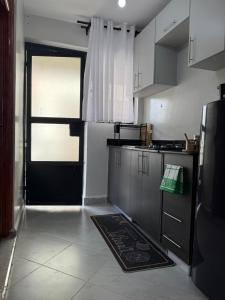 a kitchen with a black door and a kitchen rug at Solara Loft in Nairobi