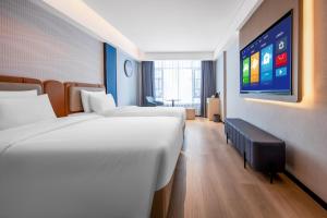 Postel nebo postele na pokoji v ubytování Huanman Hotel Hengyang Jiefang Road Lianhu Square Branch