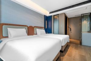 Postel nebo postele na pokoji v ubytování Huanman Hotel Hengyang Jiefang Road Lianhu Square Branch