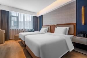 Postel nebo postele na pokoji v ubytování Huanman Hotel Hengyang Jiefang Road Lianhu Square Branch