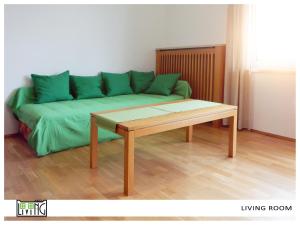 クラーゲンフルトにあるACO Living - Appartement Chill Outのリビングルーム(緑のソファ、テーブル付)