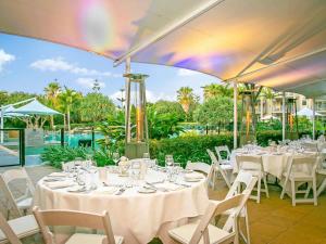 eine Gruppe von Tischen und Stühlen mit Weingläsern in der Unterkunft Peppers Salt Resort & Spa in Kingscliff