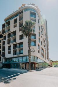 ein Gebäude mit einer Palme davor in der Unterkunft Reef Hotel & Spa in Marsalforn