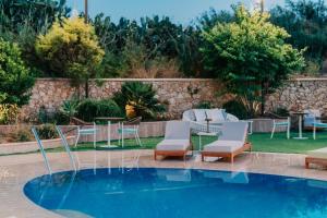 ein Swimmingpool mit Stühlen und Tischen neben einem Garten in der Unterkunft Reef Hotel & Spa in Marsalforn + 44 Fotos