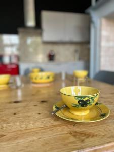 a yellow cup and saucer on a wooden table at La Maison d'Anissa-plage à 20min-Wifi-Parking in Nouvion-en-Ponthieu
