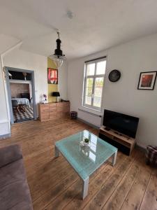 a living room with a table and a television at La Maison d'Anissa-plage à 20min-Wifi-Parking in Nouvion-en-Ponthieu