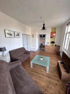 a living room with a couch and a coffee table at La Maison d'Anissa-plage à 20min-Wifi-Parking in Nouvion-en-Ponthieu +23 photos