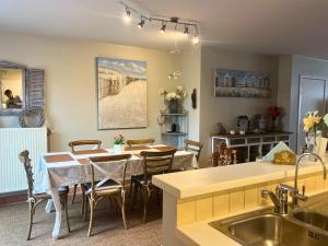 eine Küche und ein Esszimmer mit Tisch und Stühlen in der Unterkunft Le Charming duplex lumineux avec balcon, terrasse ensoleillée & parking in Knokke-Heist