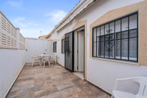 a patio with a table and chairs and a building at Geani in La Marina