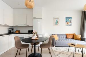 Vapari - Tampere Soccer Stadium by Come in! في تامبير: غرفة معيشة بها طاولة وأريكة