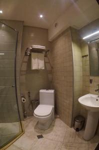 a bathroom with a toilet and a sink at TM Apart Hotel in Tbilisi City +59 photos